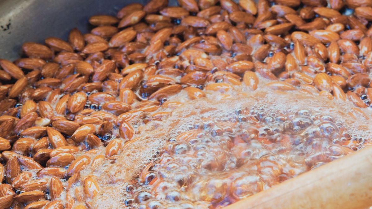 Selbstgemachte gebrannte Mandeln: Die Mandeln in der Zuckerlösung erhitzen, bis sie von allen Seiten mit Karamell überzogen sind.
